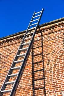 Ladder by brick wall