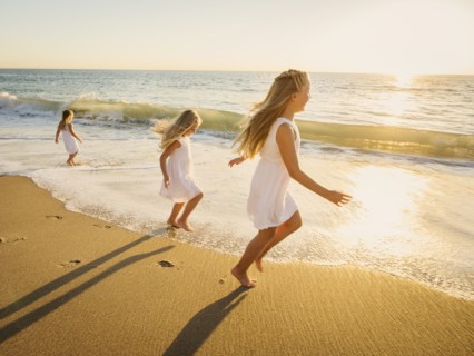 Girls (4-5, 6-7, 8-9) running on beach