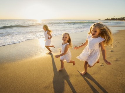 Girls (4-5, 6-7, 8-9) running on beach