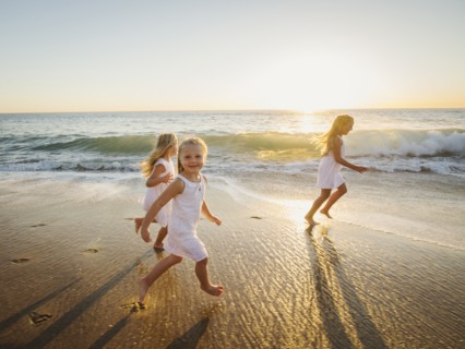 Girls (4-5, 6-7, 8-9) running on beach