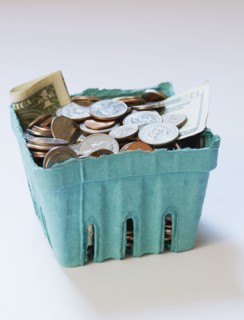 Coins and banknotes in carton box on on white surface