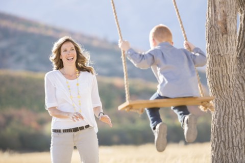 Mother with child (4-5) sitting on swing