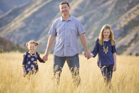 Father with two daughters (4-5, 8-9) walking in field