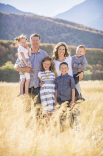 USA, Utah, Provo, Family with three children (4-5, 6-7, 8-9) standing in field