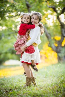 Girl holding sister in cherry orchard