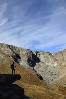 USA, Colorado, Silhouette of hiker on rock ledge along Chicago Lakes Trail in Mount Evans Wilderness Area