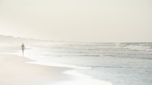 USA, North Carolina, Woman walking on empty beach