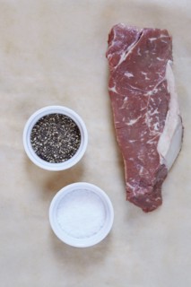Raw rib eye steak on parchment paper
