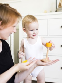 Mother playing with son (12-17 months) in nursery