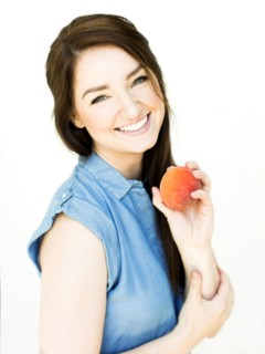Woman wearing blue top holding peach