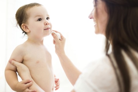 Mother cleaning son (2-3) face