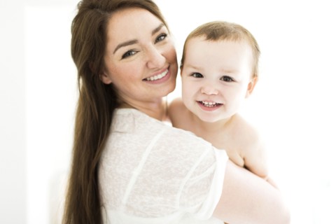 Mother carrying son (4-5) and smiling