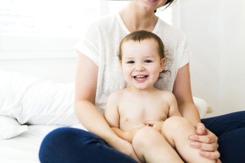 Mother sitting with son (4-5) on bed