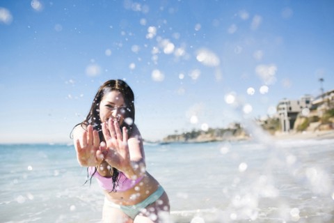 USA, California, Woman playing in water on Laguna Beach