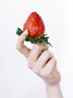Woman holding fresh strawberry