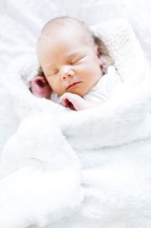 Baby boy (2-5 months) sleeping in white blanket