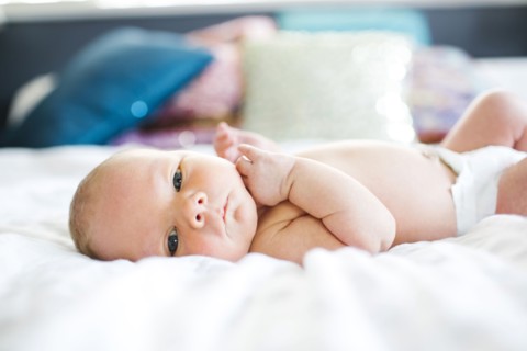 Baby boy (2-5 months) lying in bed