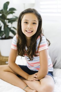 Portrait of content girl (10-11) sitting with legs crossed