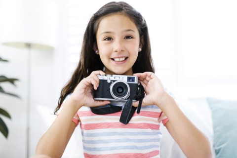 Smiling girl  (10-11) with camera