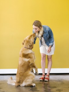 Young woman playing with golden retriever