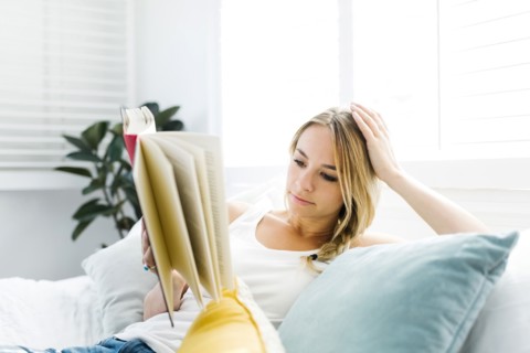 Woman reading book on sofa