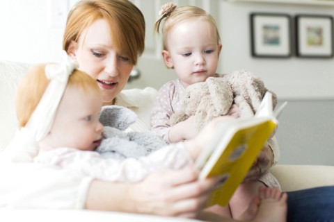 Mother reading book to daughters ( 12-17 months )