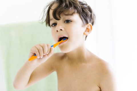 Boy (6-7) brushing teeth