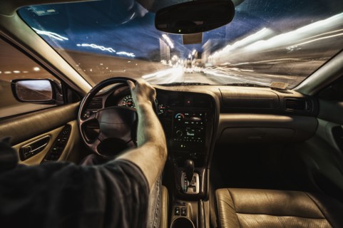 Interior of car driving through city streets at dusk