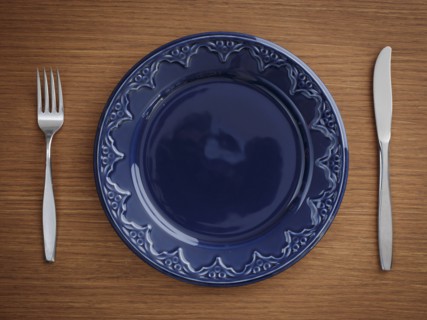 Studio shot of blue plate with fork and knife
