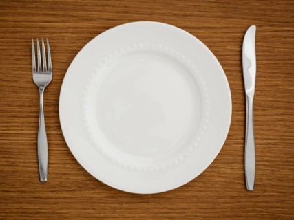 Studio shot of white plate with fork and knife