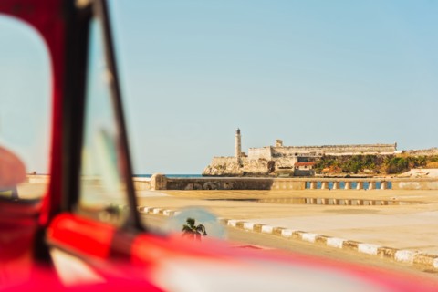 Cuba, Havana, Fort with lighthouse seen from convertible