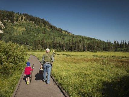 USA, Utah, Lake City, Boy (4-5) with grandfather walking on boardwalk through wetland