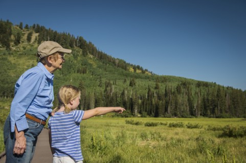 USA, Utah, Lake City, Girl (4-5) with grandmother standing on boardwalk by wetland