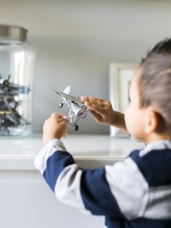 Boy (2-3) playing with model airplane