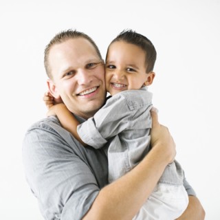 Father and son (2-3) embracing and smiling