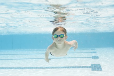 Boy (6-7) swimming in pool