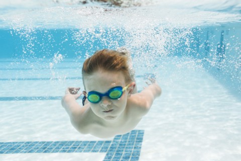 Boy (6-7) swimming in pool