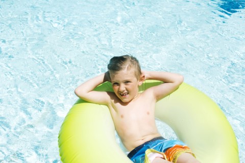 Boy (4-5) relaxing in inflatable ring