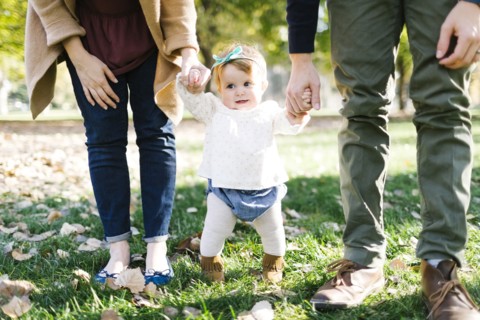 Parents walking with daughter (12-17 months) in park