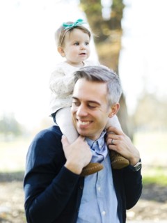 Father carrying daughter (12-17 months) on shoulders