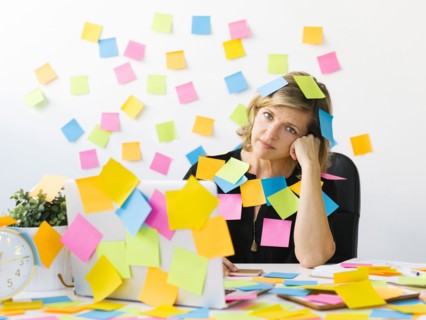 Portrait of Mature woman at office covered with adhesive notes