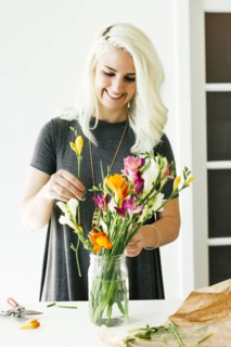 Woman putting flowers into jar