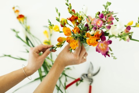 Woman putting flowers into jar