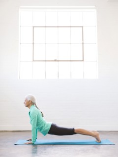 Senior woman practicing yoga on mat
