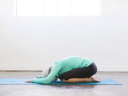 Senior woman practicing yoga on mat