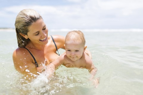 Mother playing with son (12-17 months) in sea
