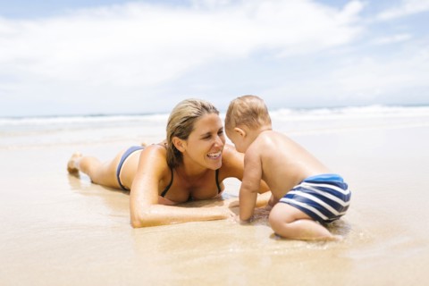 Mother playing with son (12-17 months) on beach
