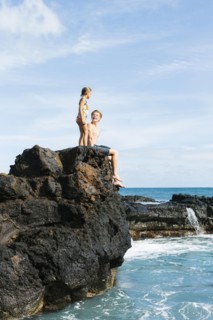 Man and girl (6-7) resting on cliff