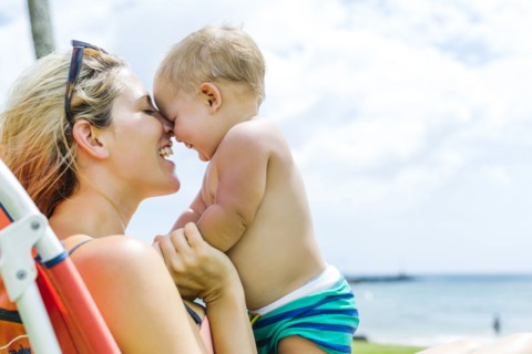 Woman sitting on deck chair with little son (18-23 months)