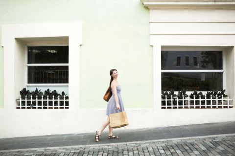 Puerto Rico, San Juan, Woman with shopping bag walking city streets